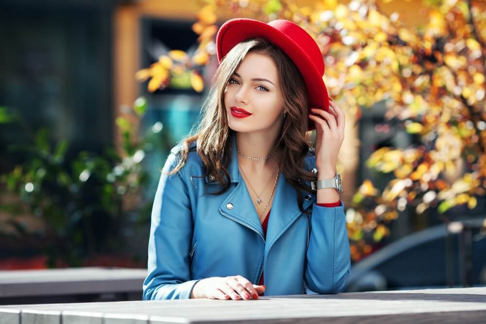 žena sa crvenim šeširom i plavom košuljom